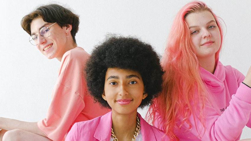 Three people dressed in shades of pink